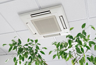 Climatisation cassette de plafond pour bureau moderne Climatisation cassette encastrée au plafond d'un bureau moderne, diffusant de l'air au-dessus de plantes vertes luxuriantes